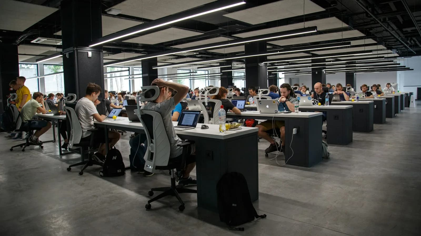 Enterprise team reviewing a wall of connected workflow diagrams and software tools